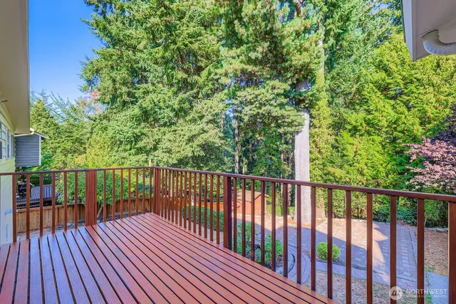 a balcony with wooden floor and trees in the background