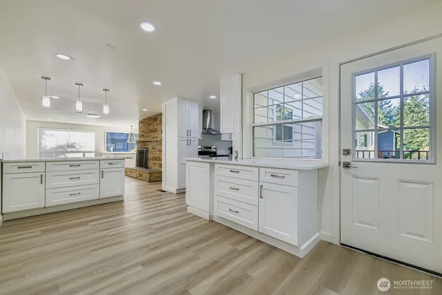 a kitchen with stainless steel appliances kitchen island granite countertop a stove top oven a sink with cabinets and wooden floor