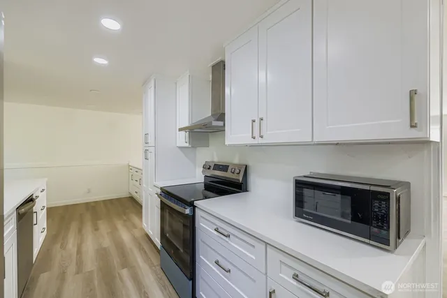 a kitchen with granite countertop white cabinets stainless steel appliances and sink