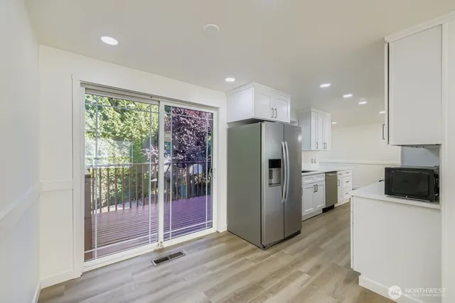 a kitchen with stainless steel appliances a refrigerator and wooden floor