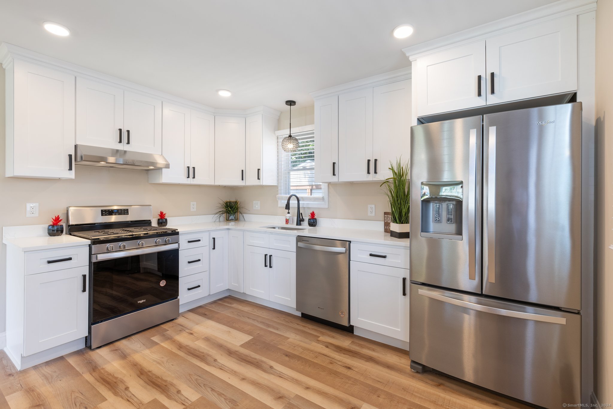 a kitchen with stainless steel appliances a refrigerator sink and stove top oven