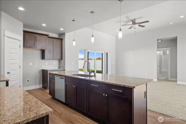 a large kitchen with granite countertop a sink and a refrigerator