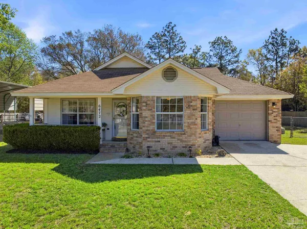 a front view of a house with a yard and outdoor seating