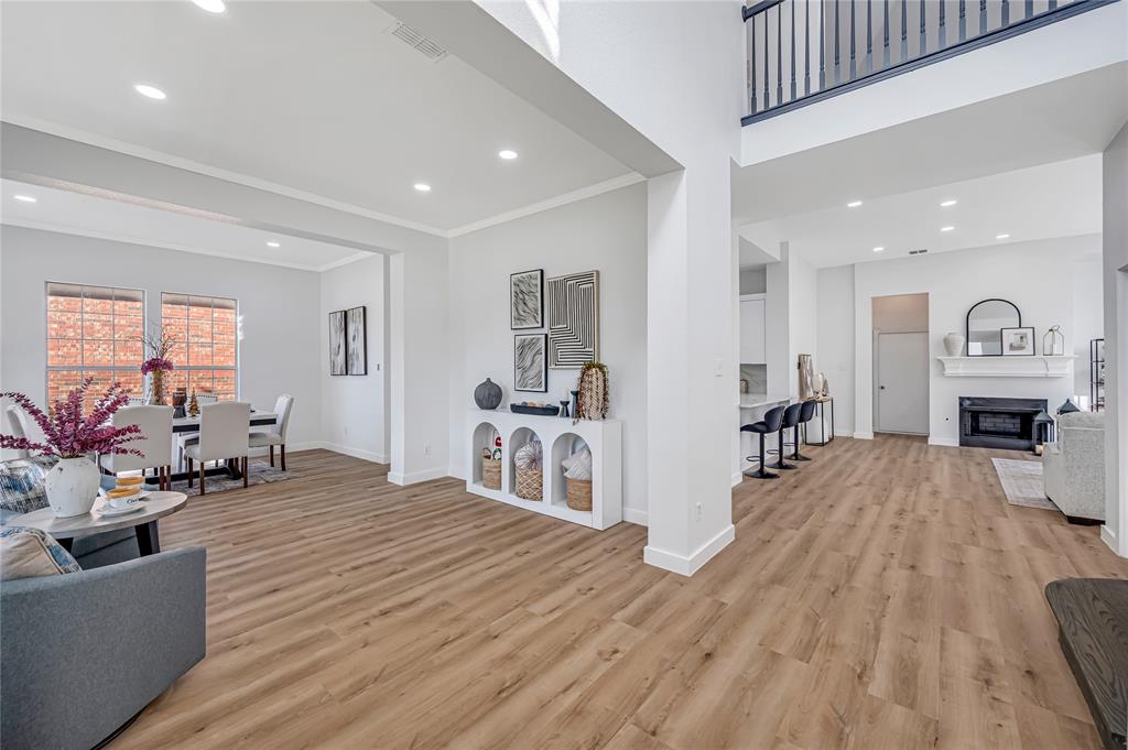 4609 Forest Park Road Plano, TX 75024 - Photo 18 of 24 Living room featuring a fireplace, recessed lighting, light wood-style floors, crown molding, and a high ceiling