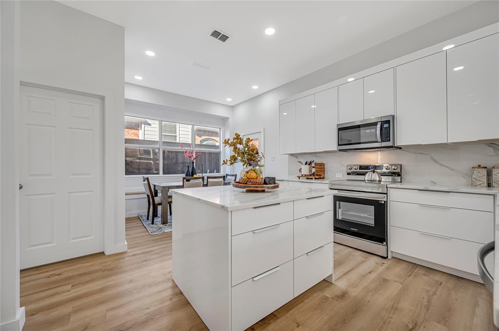 4609 Forest Park Road Plano, TX 75024 - Photo 8 of 24 Kitchen featuring modern cabinets, white cabinetry, stainless steel appliances, a kitchen island, and recessed lighting