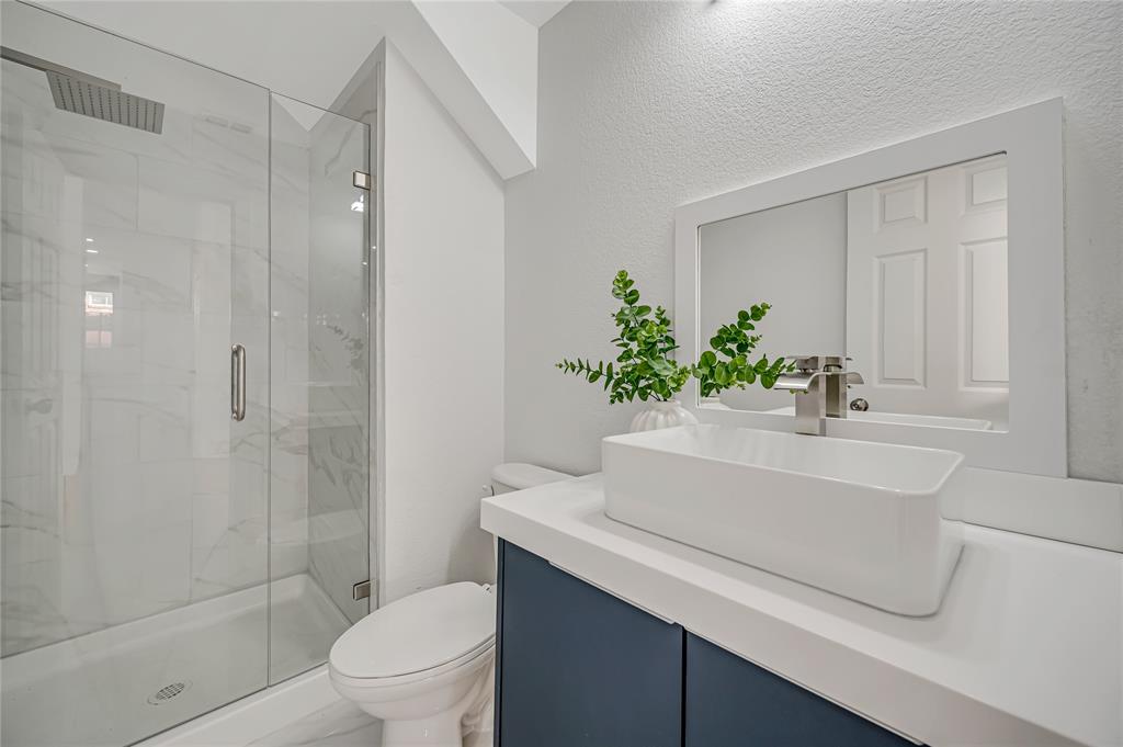 4609 Forest Park Road Plano, TX 75024 - Photo 9 of 24 Bathroom featuring vanity, a marble finish shower, and a textured wall