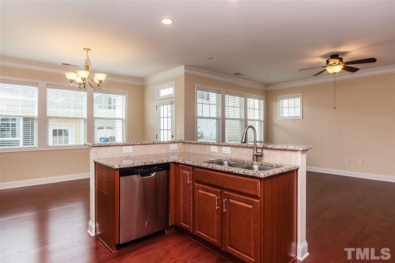 1553 Fullerton Place Raleigh, NC 27607 - Photo 12 of 25 a kitchen with granite countertop a sink and dishwasher with wooden floor