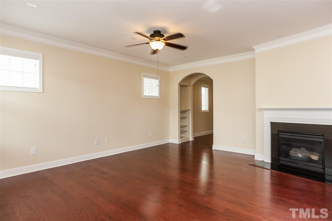 1553 Fullerton Place Raleigh, NC 27607 - Photo 5 of 25 a view of an empty room with a fireplace and wooden floor