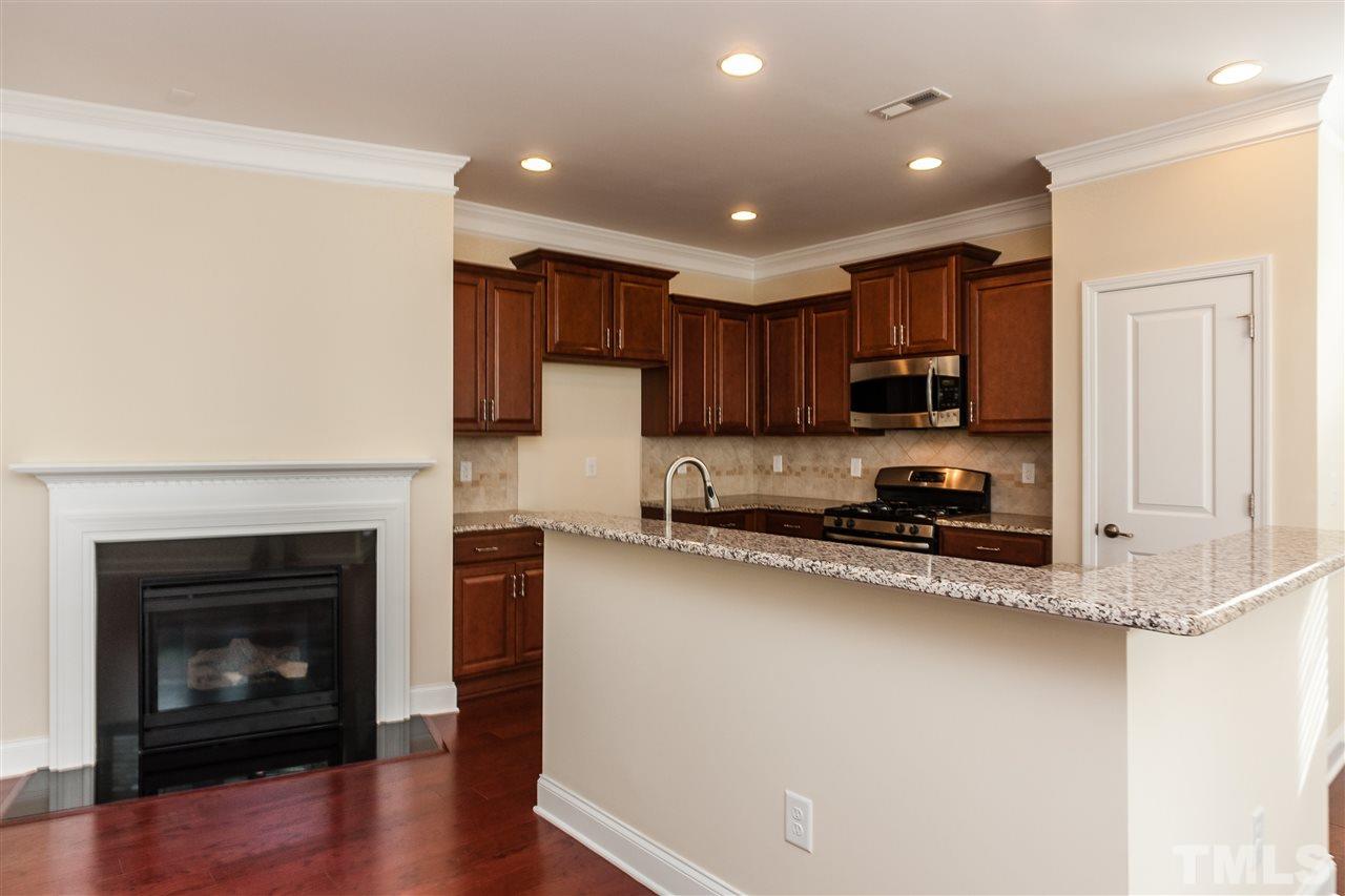 1553 Fullerton Place Raleigh, NC 27607 - Photo 7 of 25 a kitchen with a refrigerator a stove top oven a sink and a potted plant