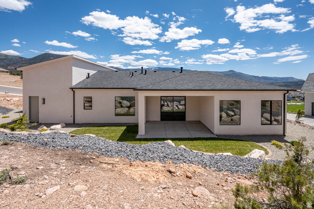 2862 South Mountain Rnch Road Cedar City, UT 84720 - Photo 52 of 64 Contemporary rear exterior featuring a covered patio with concrete flooring, stucco siding, and a dark shingle roof