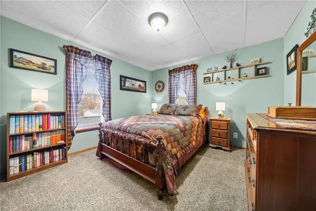 a bedroom with a bed bookshelf and a window