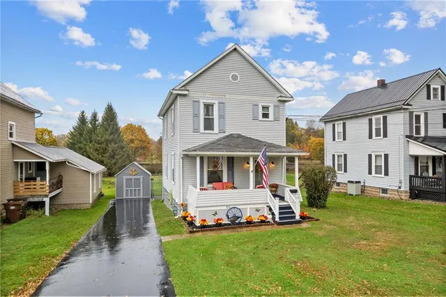 a front view of a house with a yard and trees