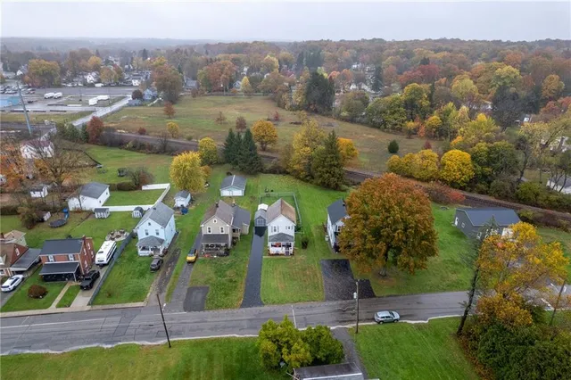 an aerial view of a house with a garden and lake view