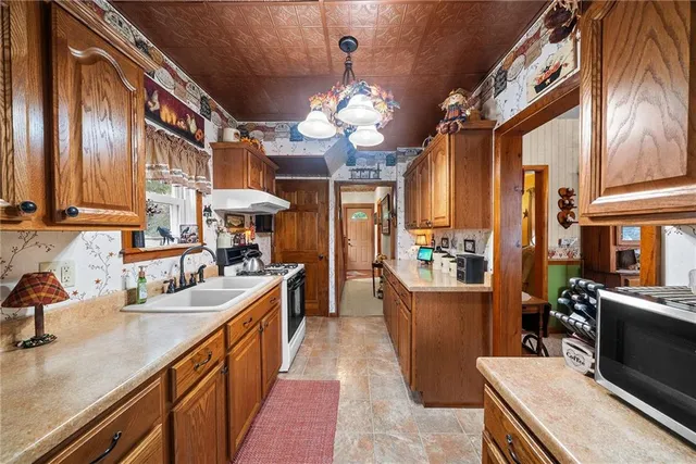 a kitchen with stainless steel appliances granite countertop a sink a stove and a wooden floors