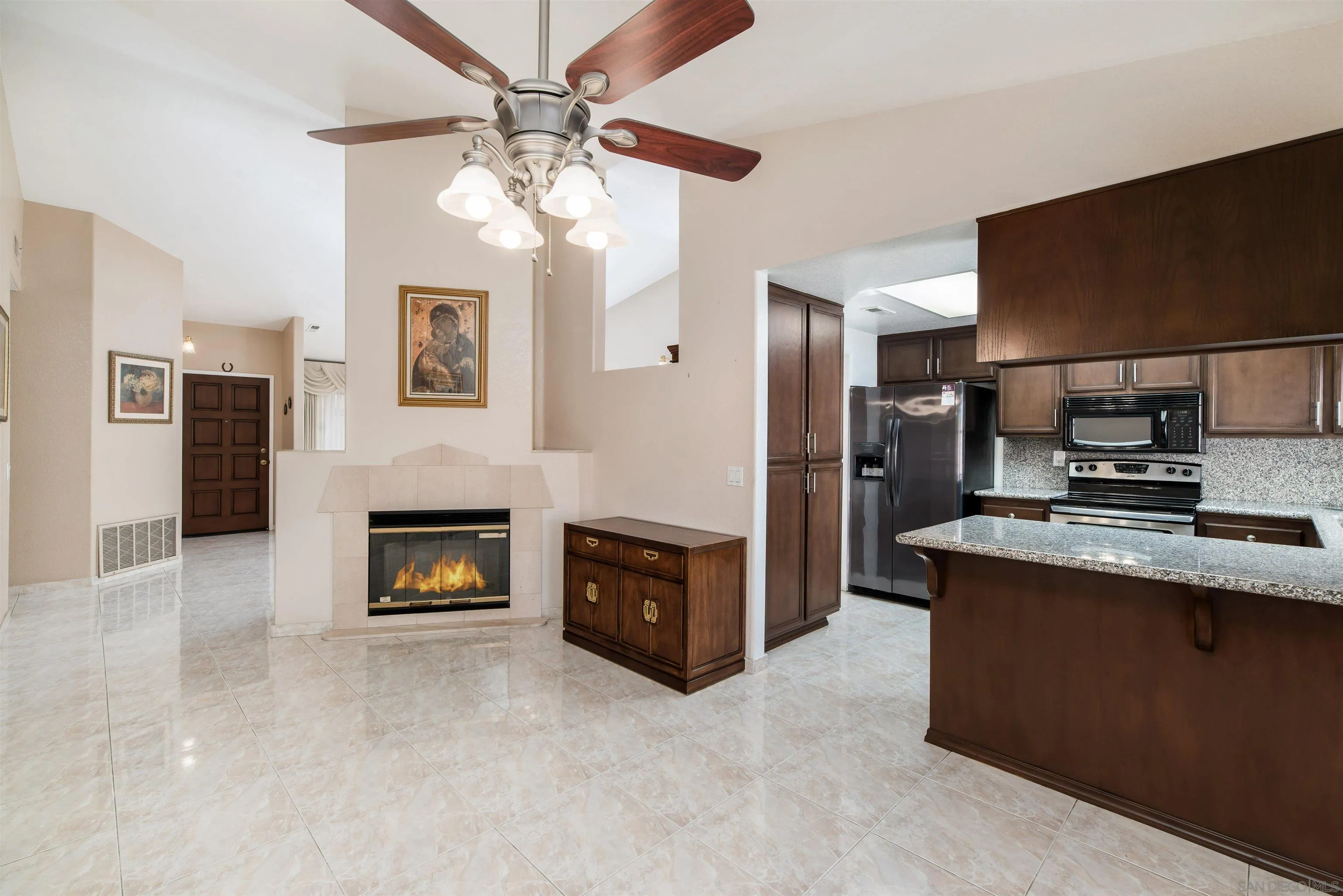 12810 Cochera Road Lakeside, CA 92040 - Photo 6 of 19 a living room with stainless steel appliances kitchen island a fireplace and a television