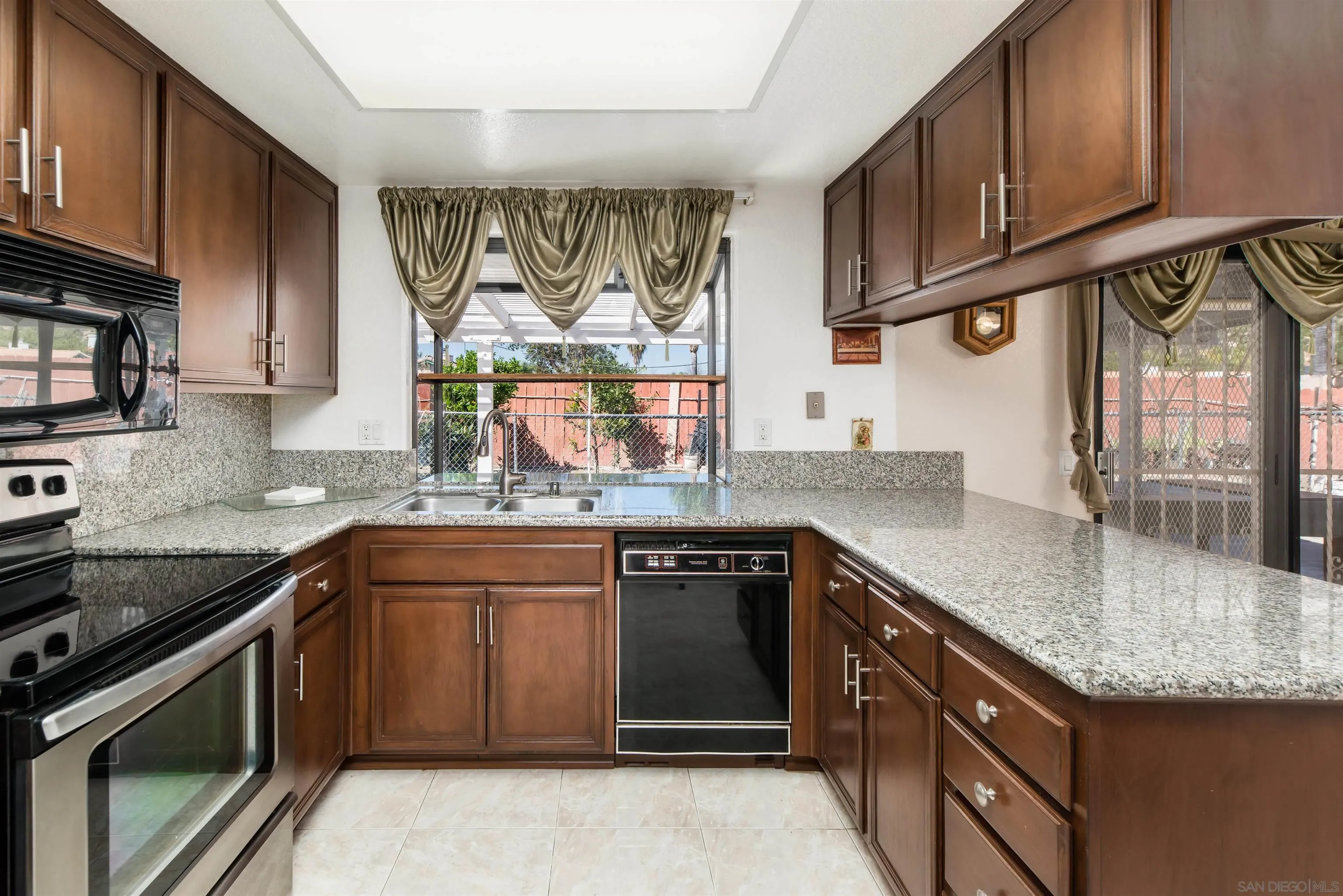 12810 Cochera Road Lakeside, CA 92040 - Photo 9 of 19 a kitchen with stainless steel appliances granite countertop a sink stove and cabinets