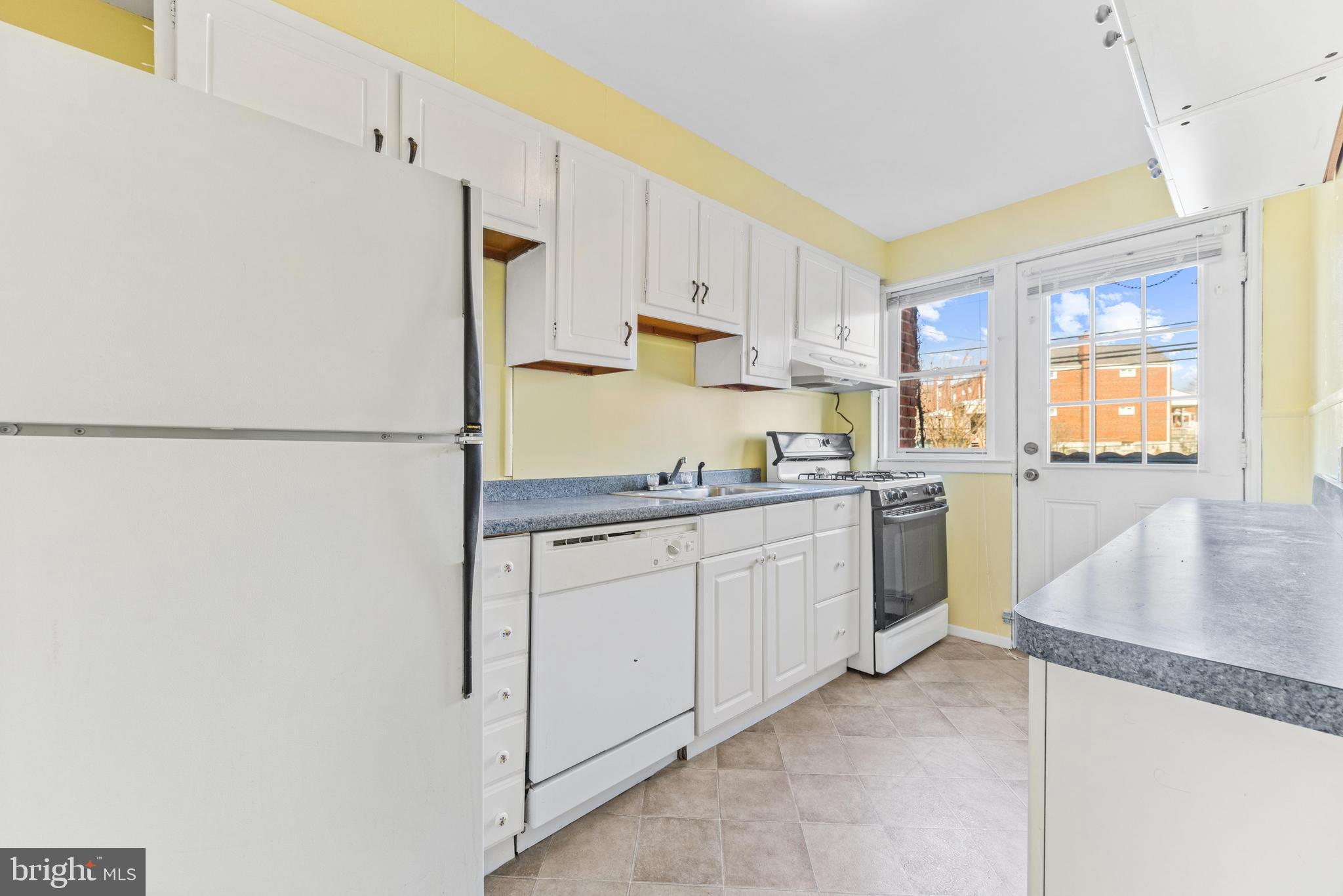 7310 Kirtley Road Baltimore, MD 21224 - Photo 10 of 31 a kitchen with granite countertop white cabinets and white appliances