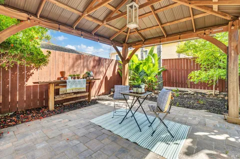 a view of patio with table and chairs under an umbrella