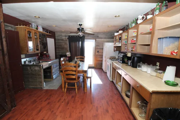 a dining room with stainless steel appliances kitchen island granite countertop a refrigerator a stove a sink and dishwasher a oven with wooden floor