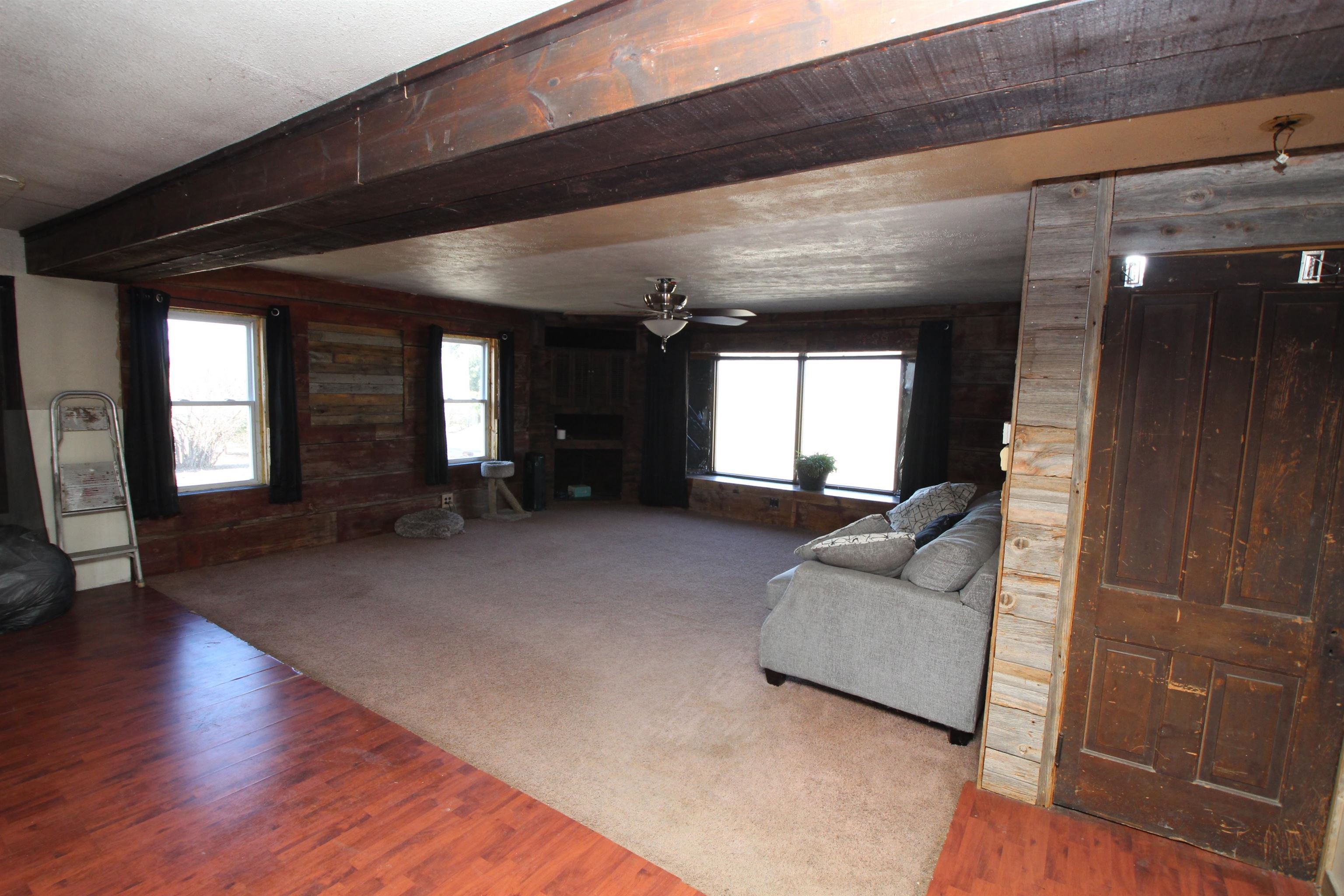 15210 Murphy Road Winnebago, IL 61088 - Photo 6 of 22 a living room with couches and a large mirror with wooden floor