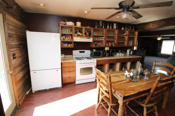 a kitchen with a dining table cabinets stainless steel appliances and a chandelier