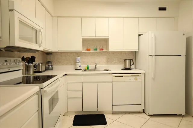 a kitchen with a white cabinets and white appliances