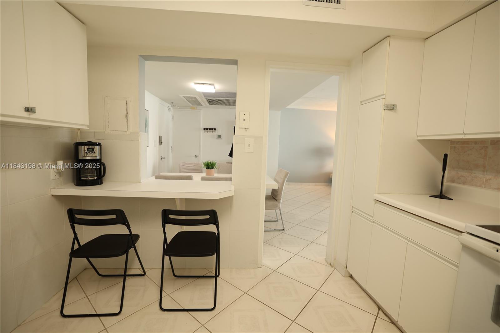 5151 Collins Avenue, Unit 927 Miami Beach, FL 33140 - Photo 13 of 19 a kitchen with a sink cabinets and window