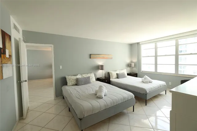 a bedroom with two beds and a window