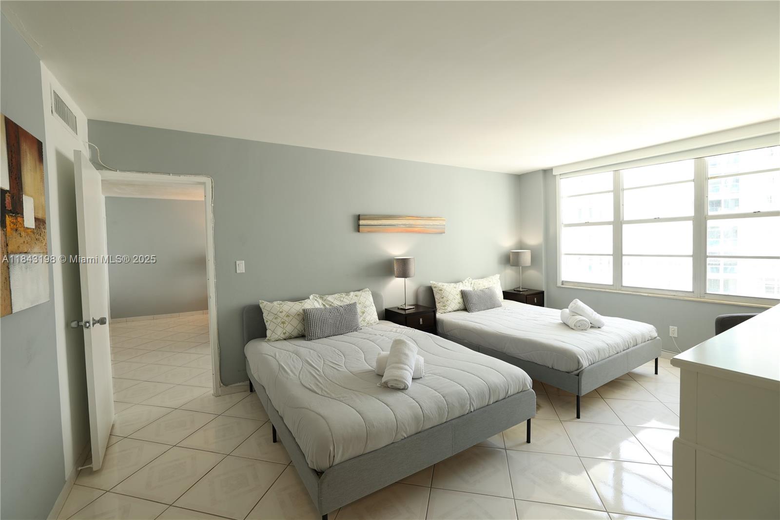 5151 Collins Avenue, Unit 927 Miami Beach, FL 33140 - Photo 6 of 19 a bedroom with two beds and a window
