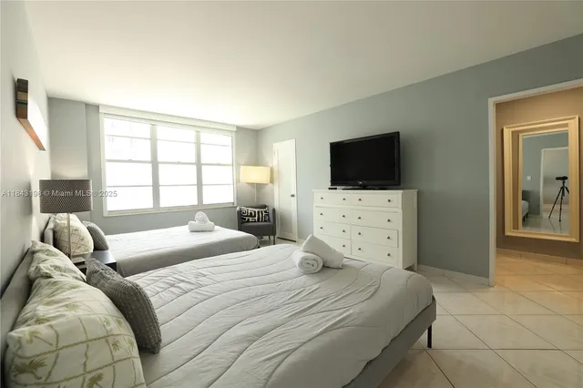 a bedroom with a bed and a flat screen tv