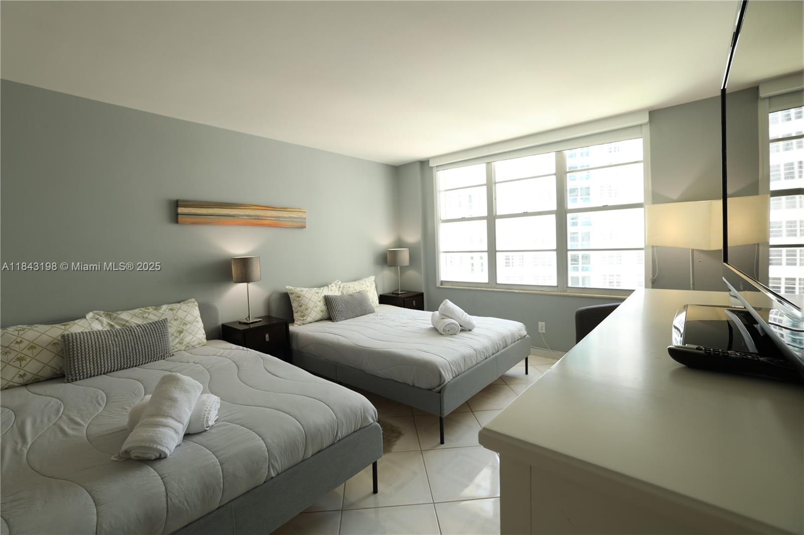 5151 Collins Avenue, Unit 927 Miami Beach, FL 33140 - Photo 8 of 19 a bedroom with two beds and a large window