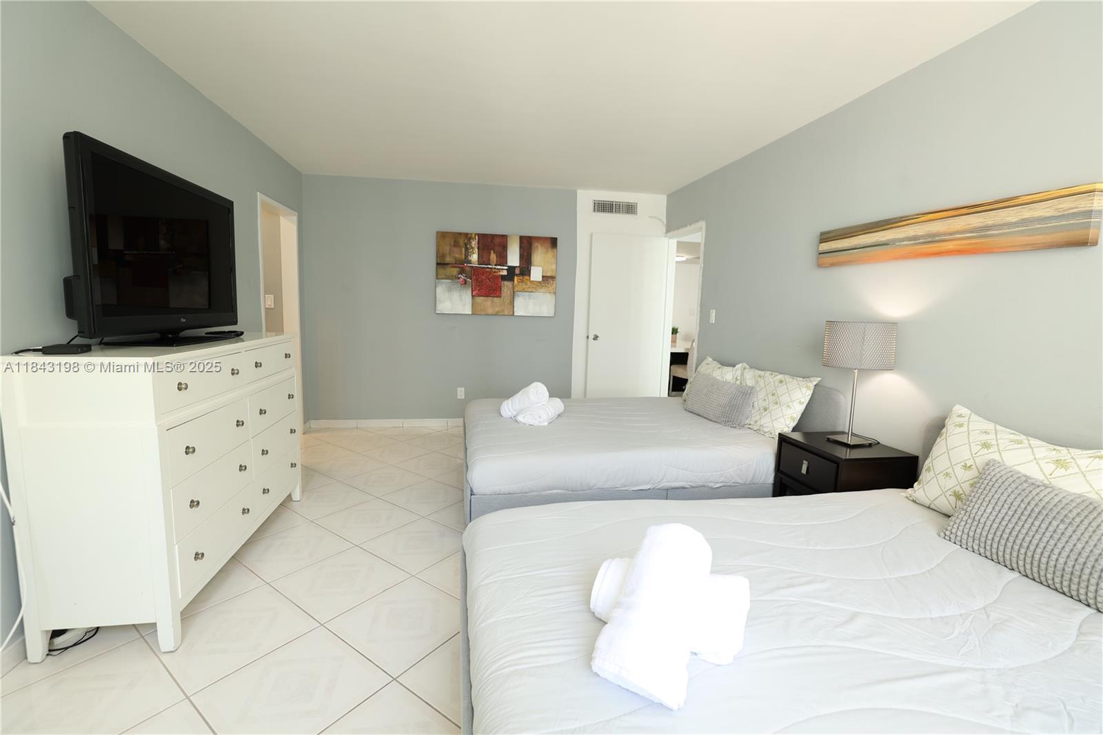 5151 Collins Avenue, Unit 927 Miami Beach, FL 33140 - Photo 9 of 19 a bedroom with a bed and a flat screen tv