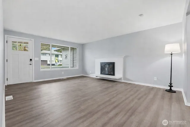 a view of a livingroom with wooden floor and a flat screen tv