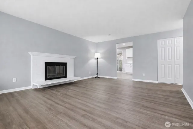 a view of empty room with wooden floor and fireplace