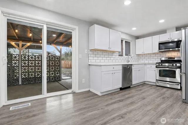 a kitchen with stainless steel appliances granite countertop a stove top oven and a refrigerator