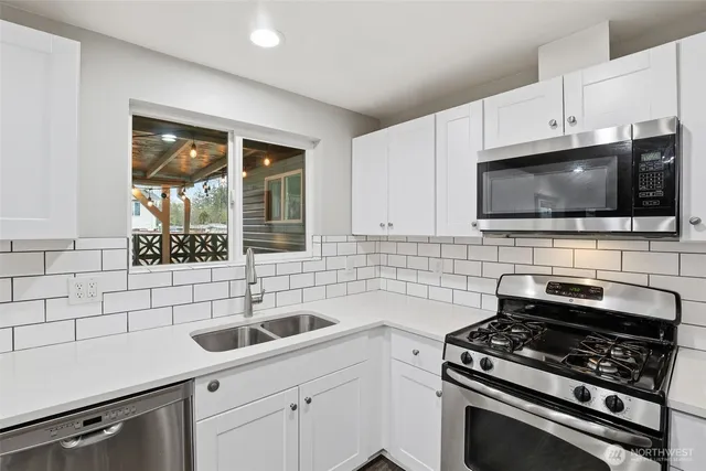 a kitchen with stainless steel appliances a stove a sink and a microwave