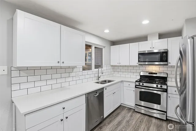 a kitchen with a sink appliances and cabinets