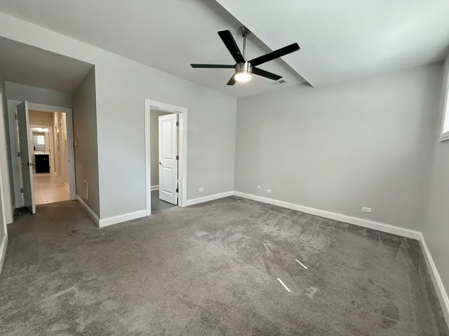 an empty room with closet and a chandelier fan