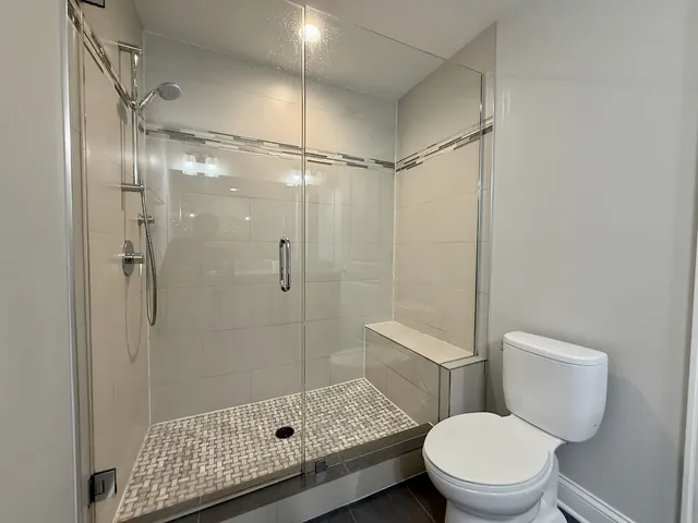a bathroom with a toilet and a shower