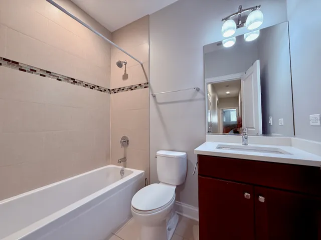a bathroom with a sink a toilet a mirror a bathtub and shower