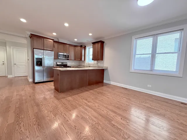 a large kitchen with stainless steel appliances granite countertop a large counter top and a stove top oven