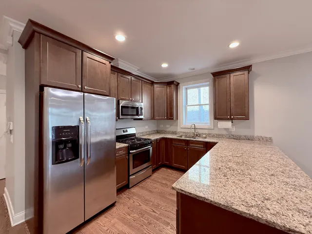 a kitchen with stainless steel appliances granite countertop refrigerator sink and microwave