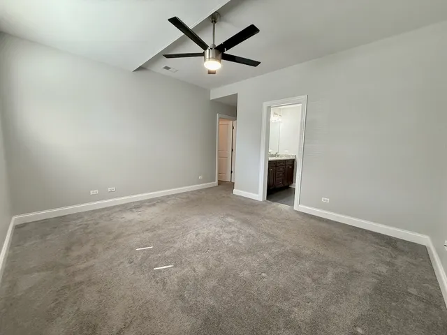 en empty room with a ceiling fan and window