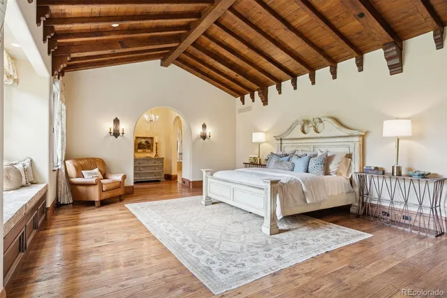 a spacious bedroom with a bed a couch and dresser