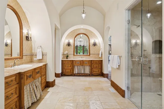 a large spacious bathroom with a mirror a sink and glass door shower