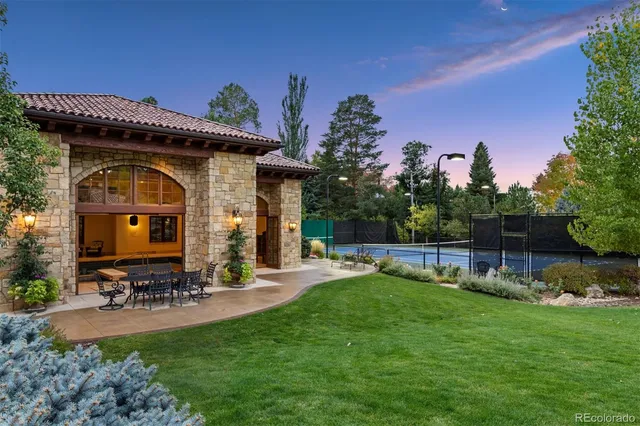 a front view of a house with a yard and fountain in middle
