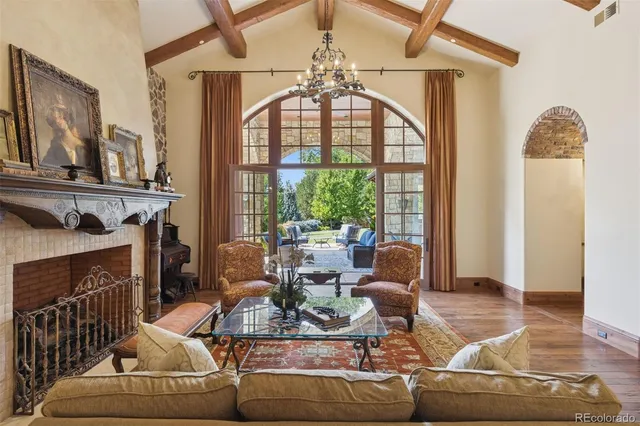a living room with furniture a fireplace and a chandelier