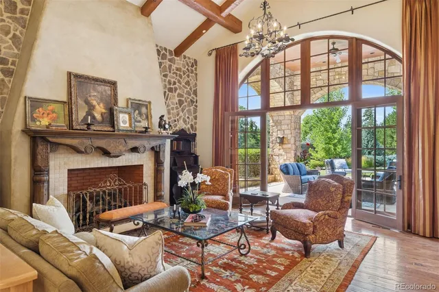 a living room with furniture a chandelier and a fireplace