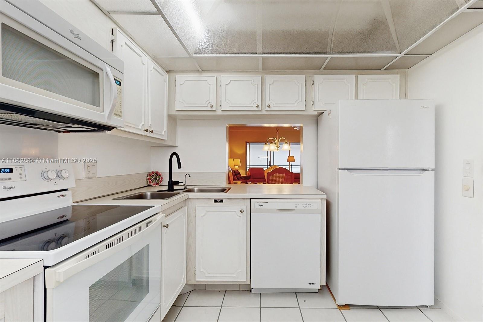 1501 South Ocean Boulevard, Unit 301 Lauderdale-by-the-Sea, FL 33062 - Photo 7 of 17 a kitchen with appliances a sink and cabinets