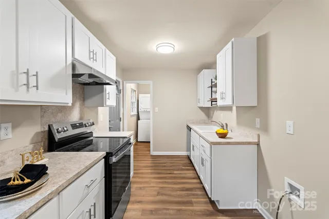 a kitchen with stainless steel appliances a sink stove and cabinets